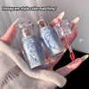 Lip gloss set with clear and blue bottles held by a hand against a neutral background.