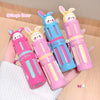 Four colorful lip balms with cartoon bear faces on a beige background