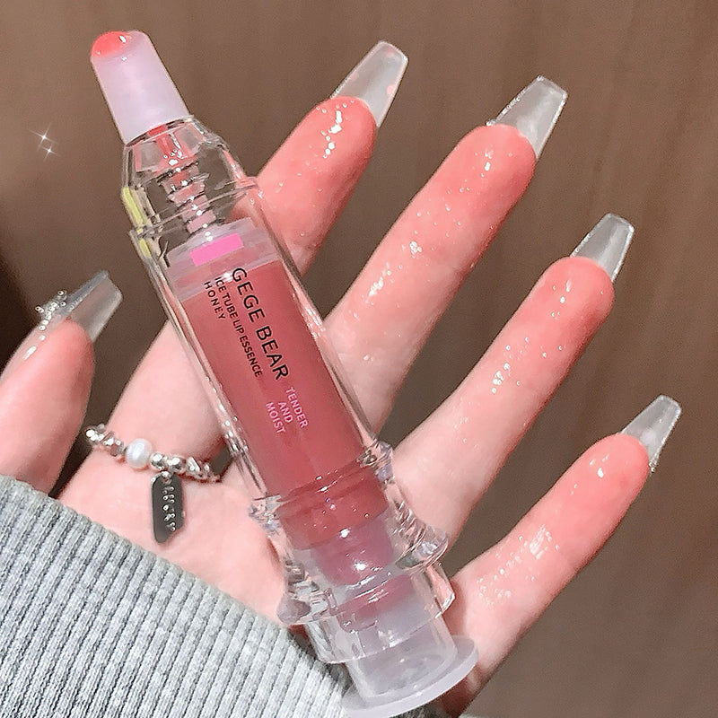 Lip gloss with 'GEGEBEAR' branding held by a hand with long, manicured nails.