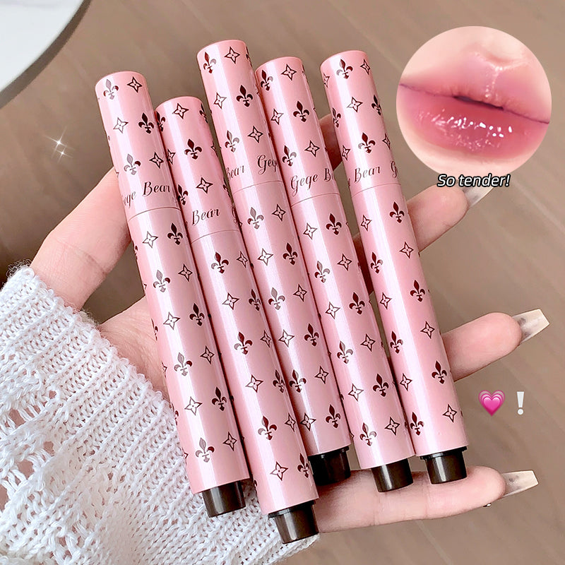 Pink lip gloss tubes with decorative patterns held by a hand, close-up of lip color shown.