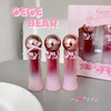 Three pink and red bottles with a box labeled 'GEGE BEAR' on a gray surface.