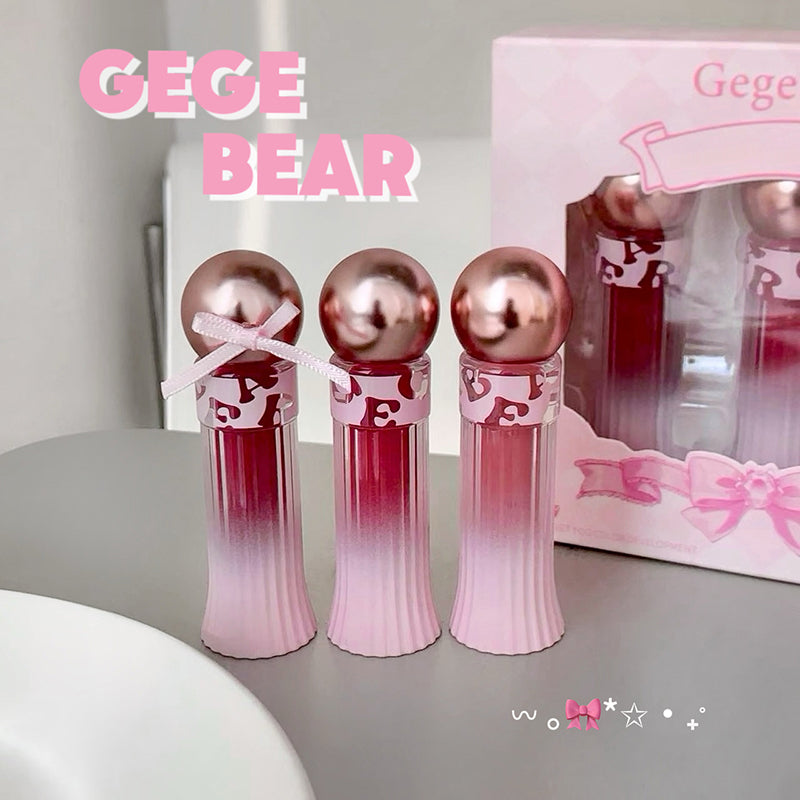Three pink and red bottles with a box labeled 'GEGE BEAR' on a gray surface.