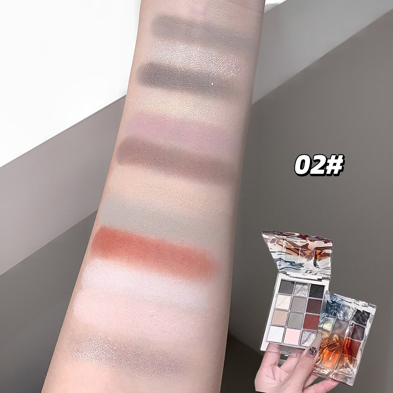 Makeup palette with swatches on a arm and a hand holding the palette.