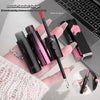 Lip gloss with double-ended design held by a hand, with laptop in background