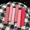 Set of six lip glosses from Gege bear on a checkered fabric background