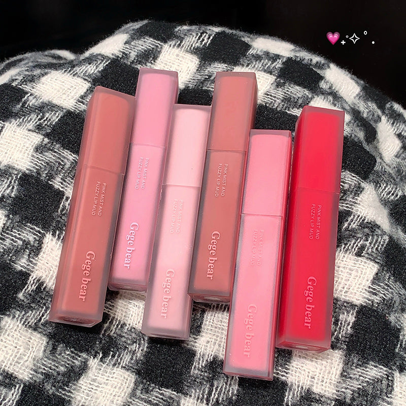 Set of six lip glosses from Gege bear on a checkered fabric background