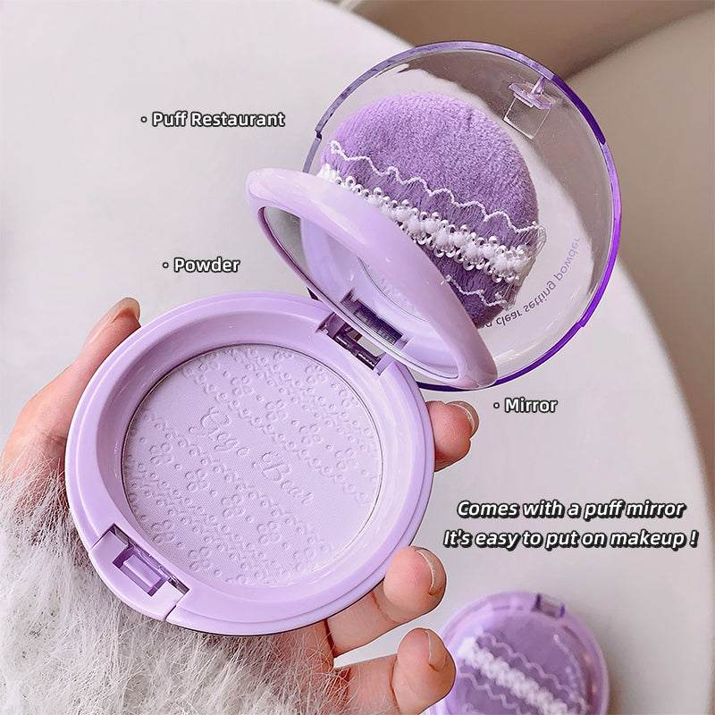 Purple makeup compact with mirror and powder, held by a hand.