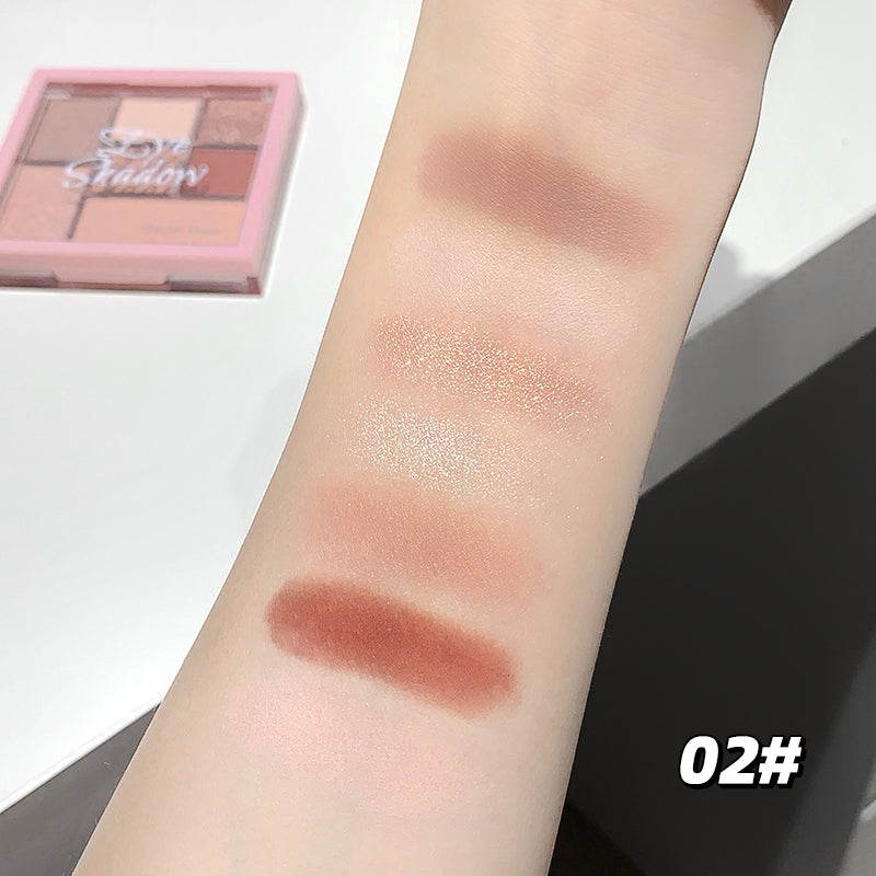 Makeup swatches on a person's arm with a makeup palette in the background