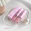 Pink cosmetic set with a heart-shaped tray on a white surface