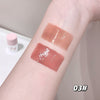 Three swatches of lip gloss on a person's arm with a neutral background