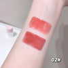 Two swatches of red lipstick on a person's arm with a blurred background