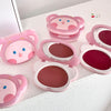 Pink bear-shaped makeup cases with lip products on a white background