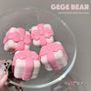 Pink lip and cheek multi-use cream containers with bows on a clear stand, branded 'GEGE BEAR'.