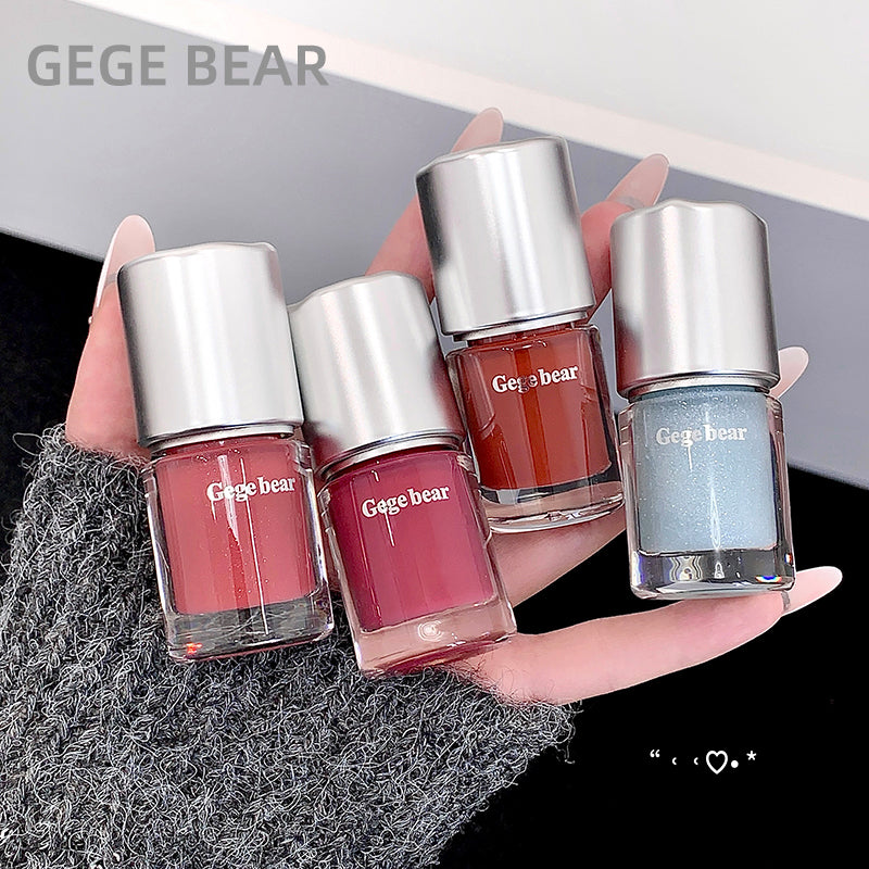 Four GEGE BEAR nail polishes held in a hand with a blurred background