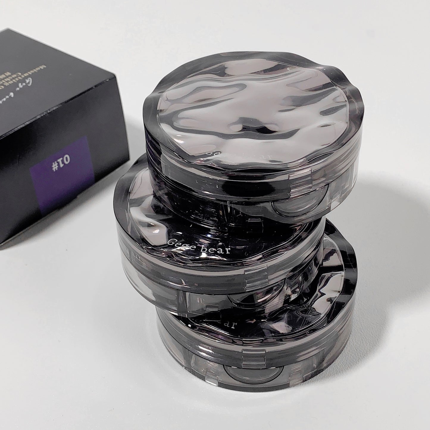Clear plastic grinder with visible branding on a white background