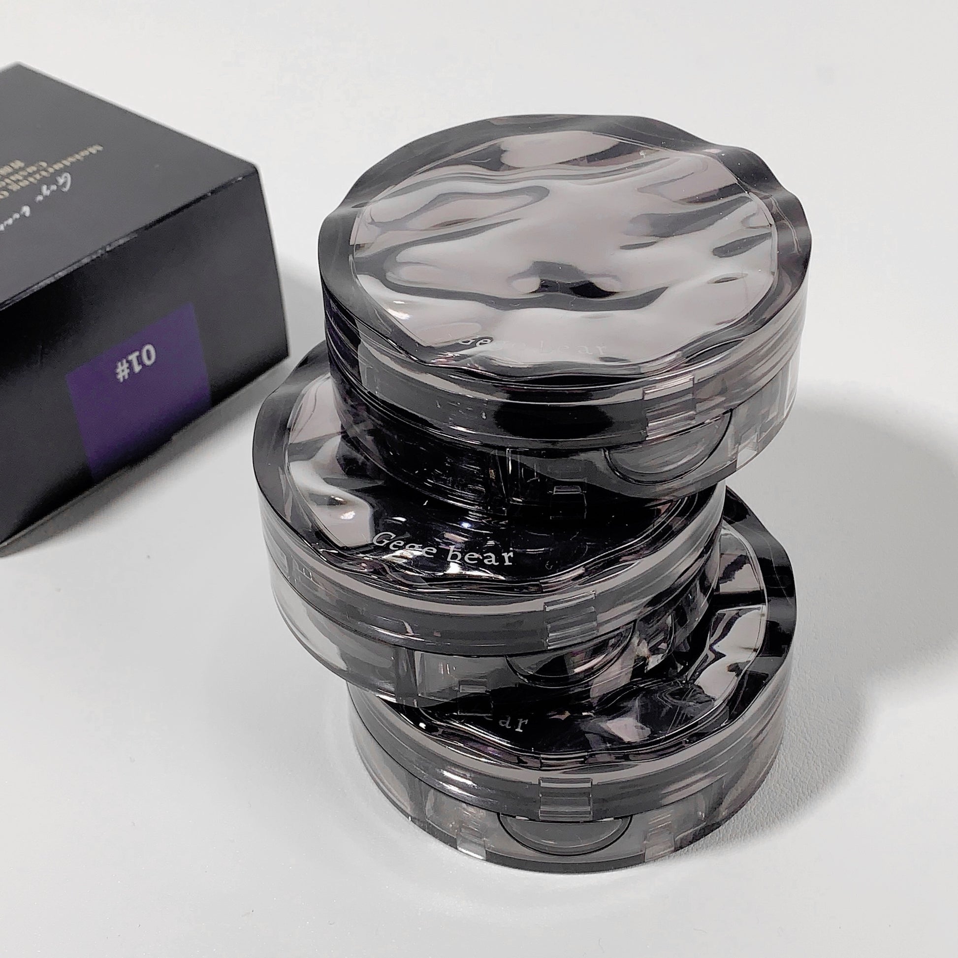 Clear plastic grinder with visible branding on a white background