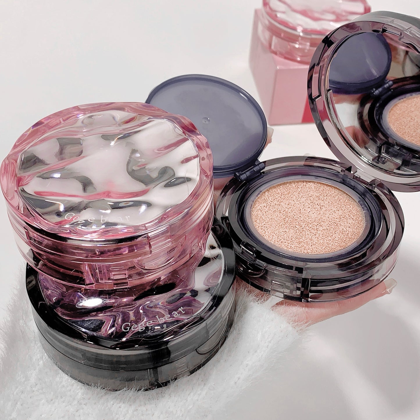 Makeup compact with pink and clear design on a white background
