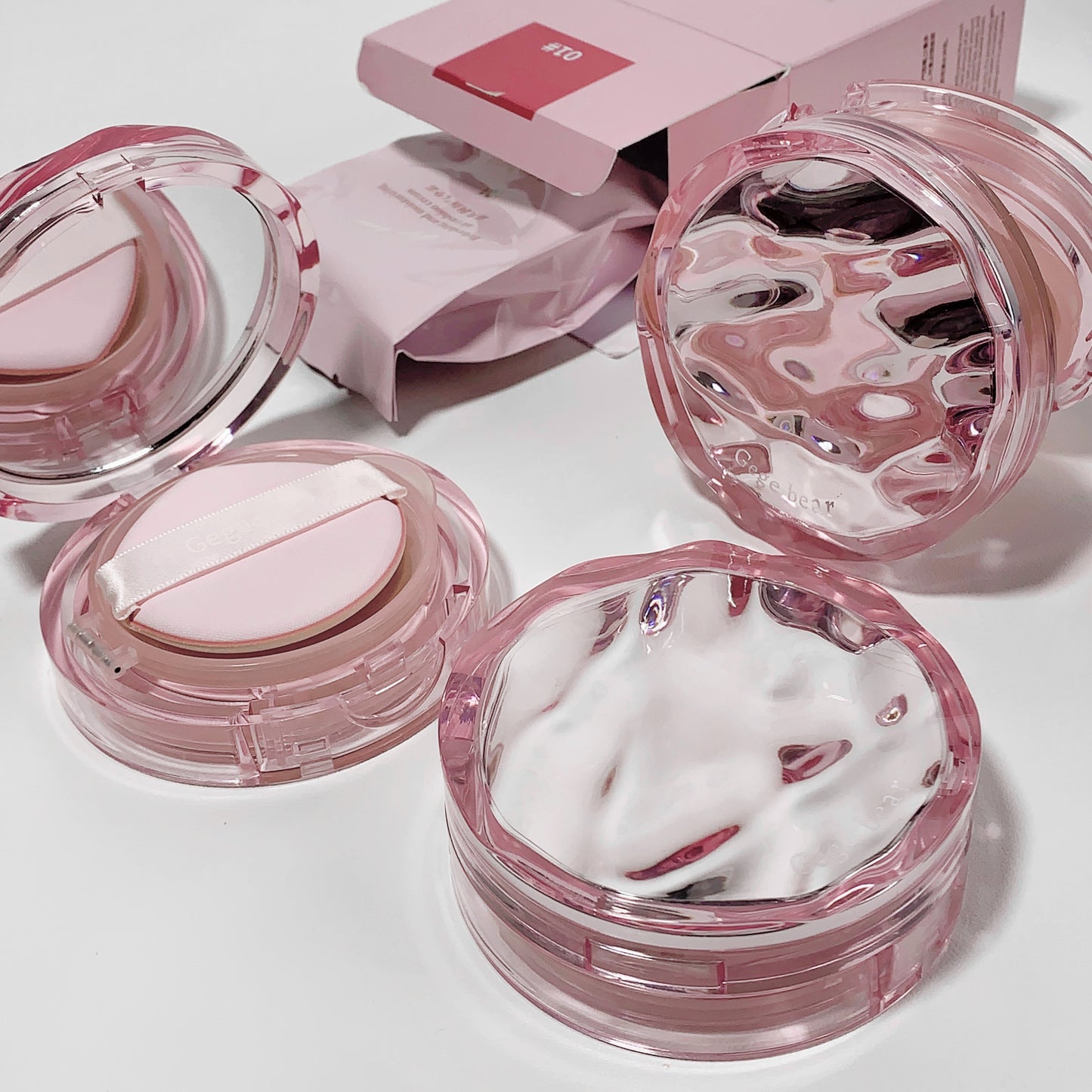 Pink cosmetic products with white cream on a light background