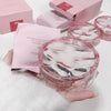 Pink cosmetic product with packaging on a white surface