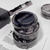 Cosmetic compact with 'Gegebear' branding on a white surface with newspaper.