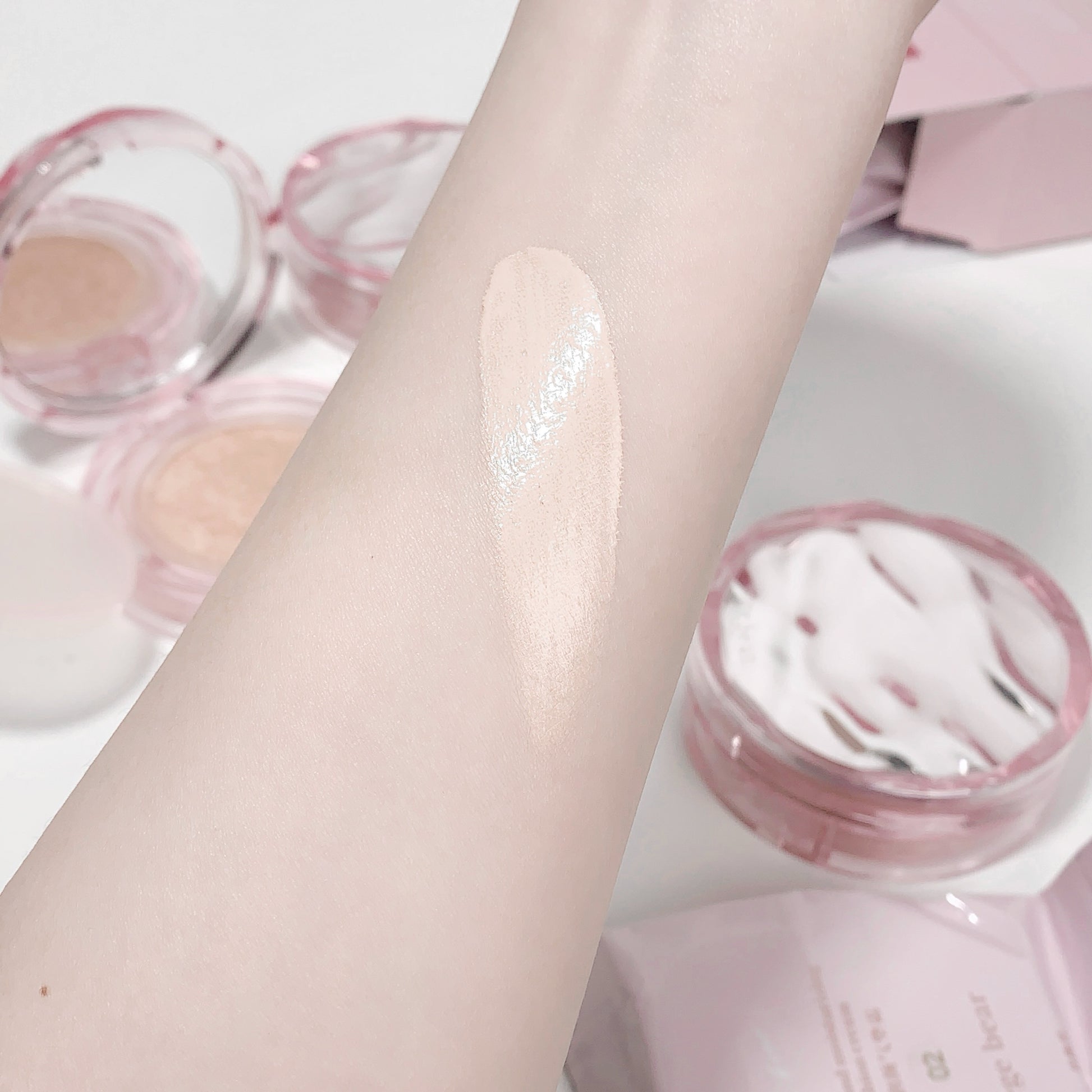 Close-up of a hand with a smooth, even application of cream on a light background.