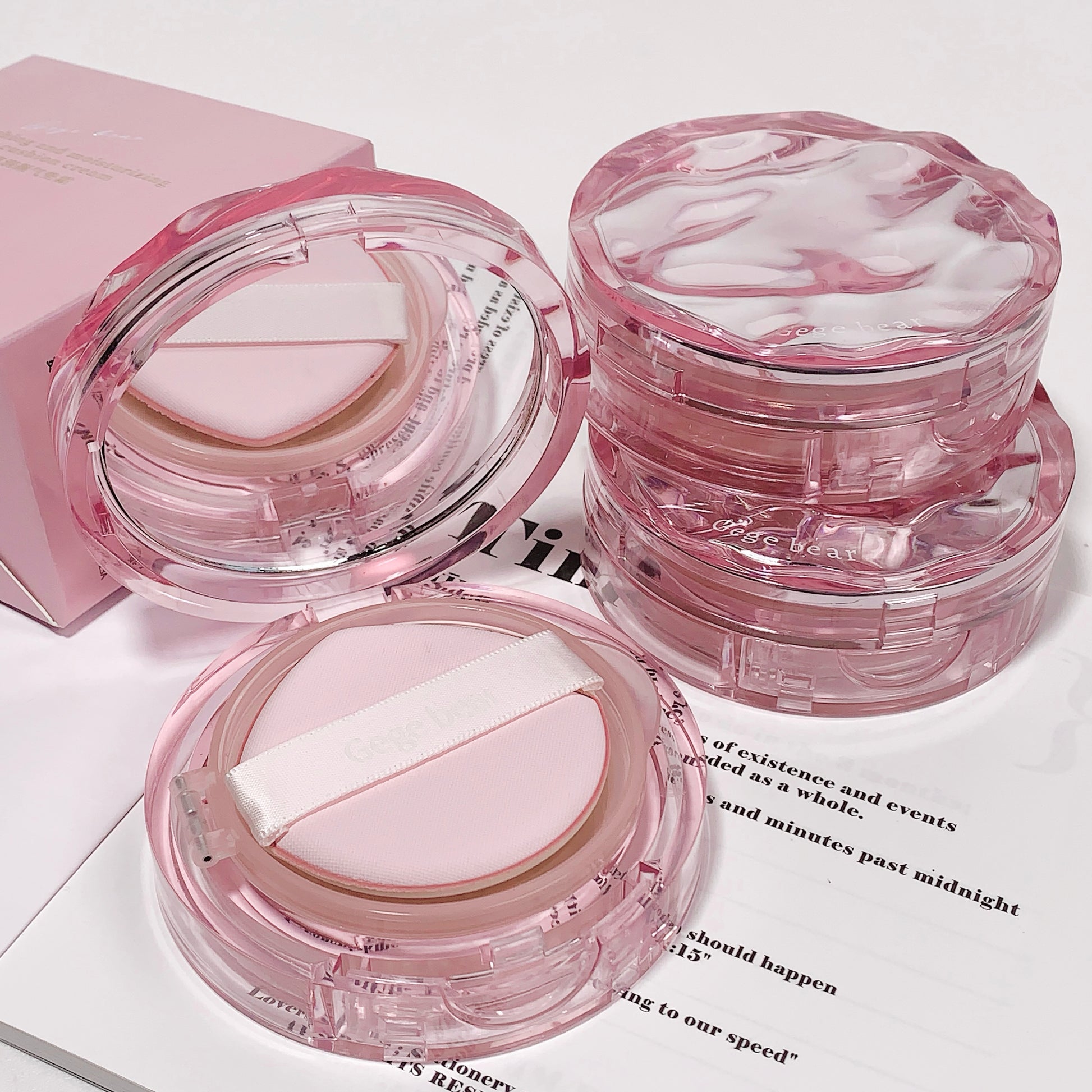 Pink cosmetic compact on a white surface with text