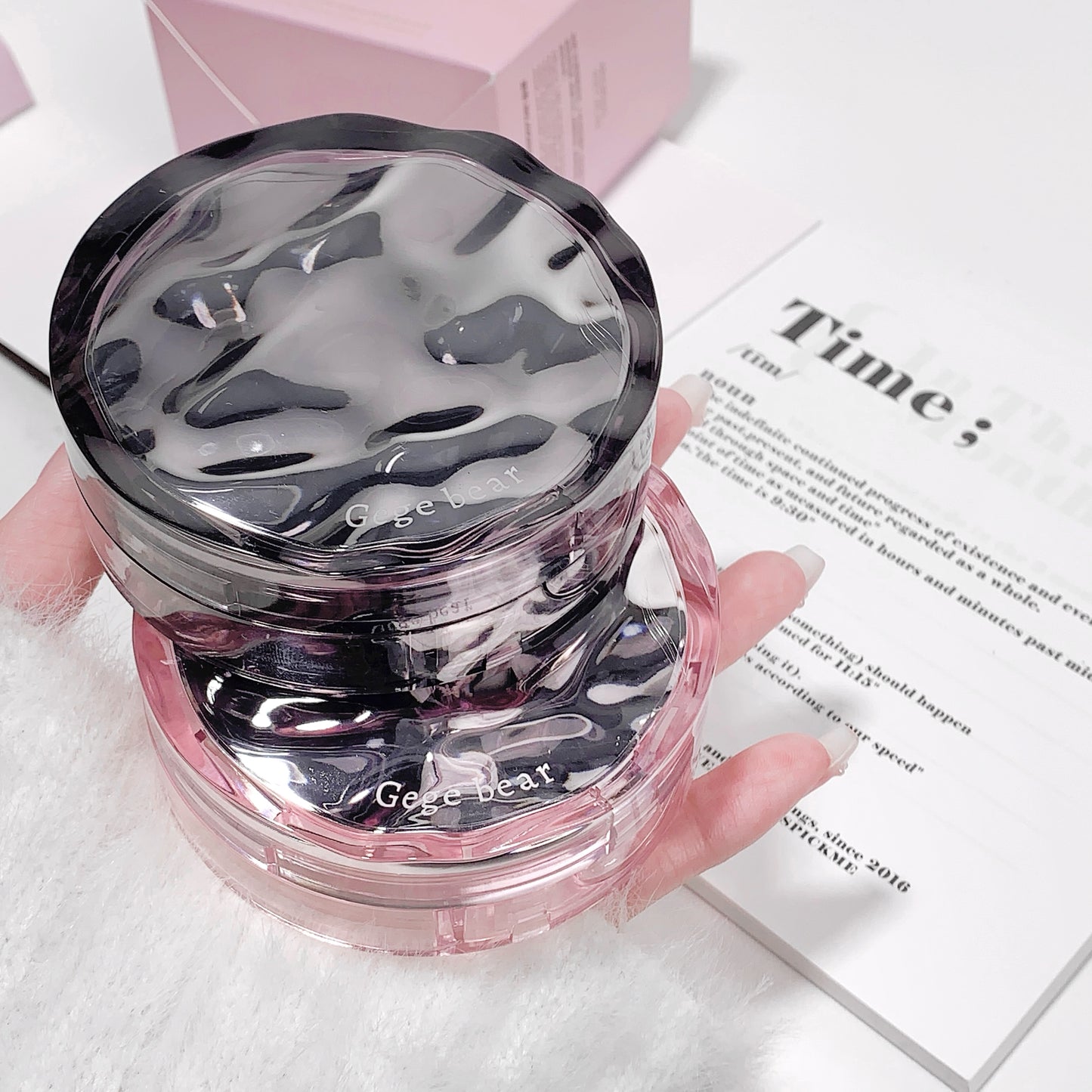 Clear jar with pink lid held by a hand on a white surface with text.