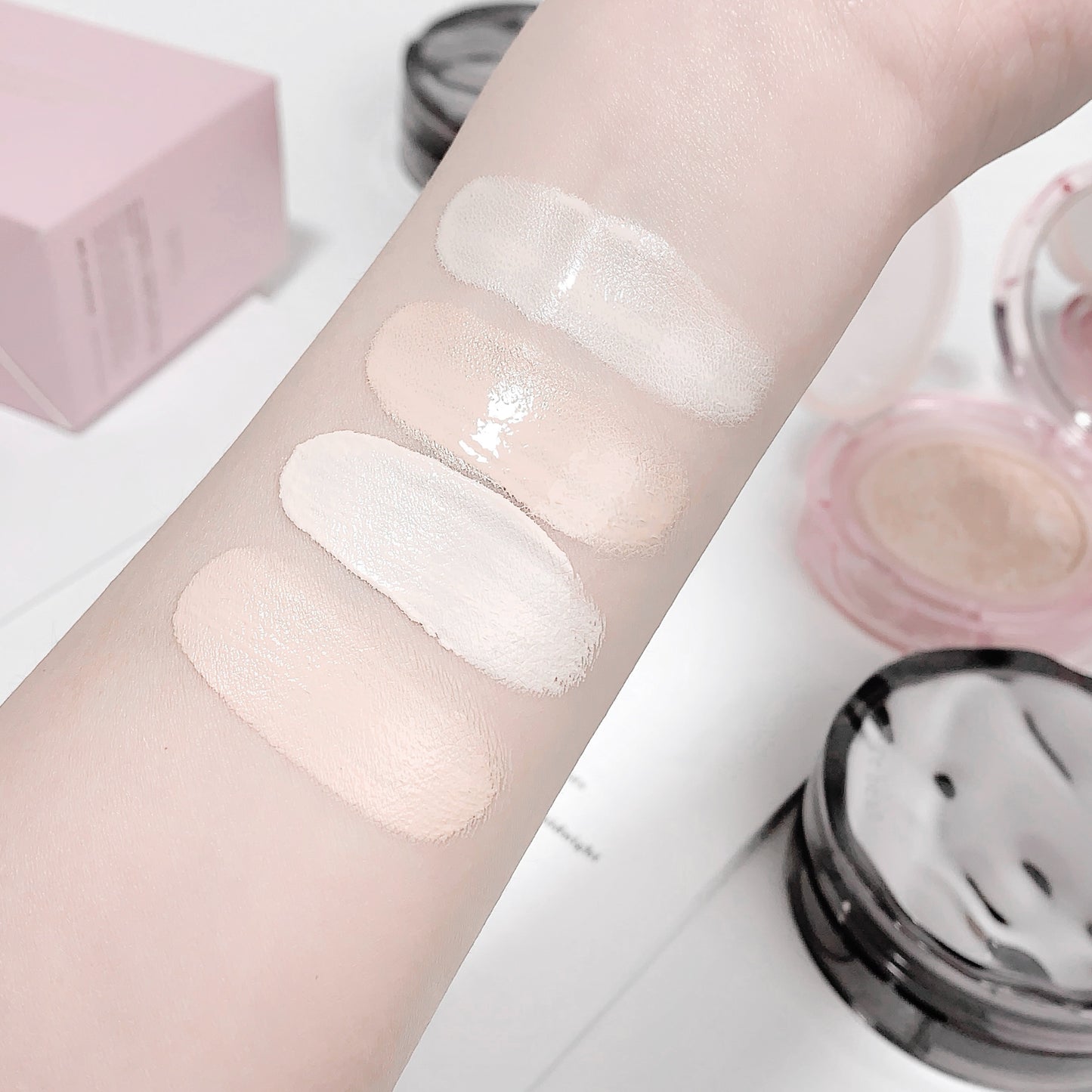 Cosmetic product swatches on a person's arm with a close-up of the product below.