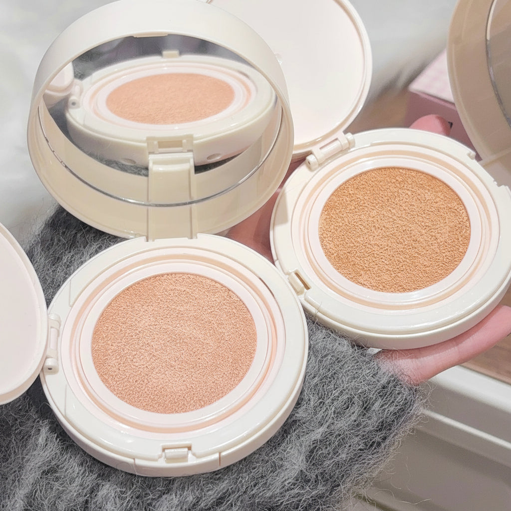 Three open compact face powders with visible color swatches on a textured surface.