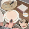 Compact powder in a white case held by a hand, with a blurred face inset on a wooden surface.
