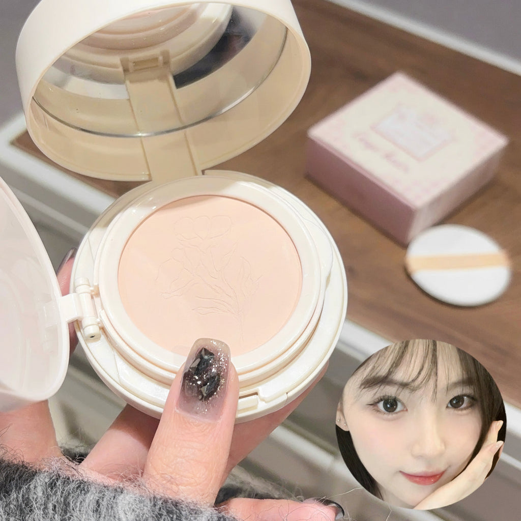 Compact powder in a white case held by a hand, with a blurred face inset on a wooden surface.