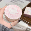 Round pink compact with 'Gege bear' branding held by a hand.