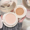 Two makeup compacts with different shades of powder, held by a hand.