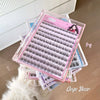 Stack of false eyelash boxes with pink packaging on a neutral background