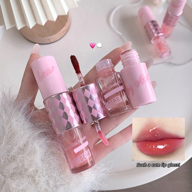 Set of pink lip glosses with a close-up of lips wearing the product on a white surface.