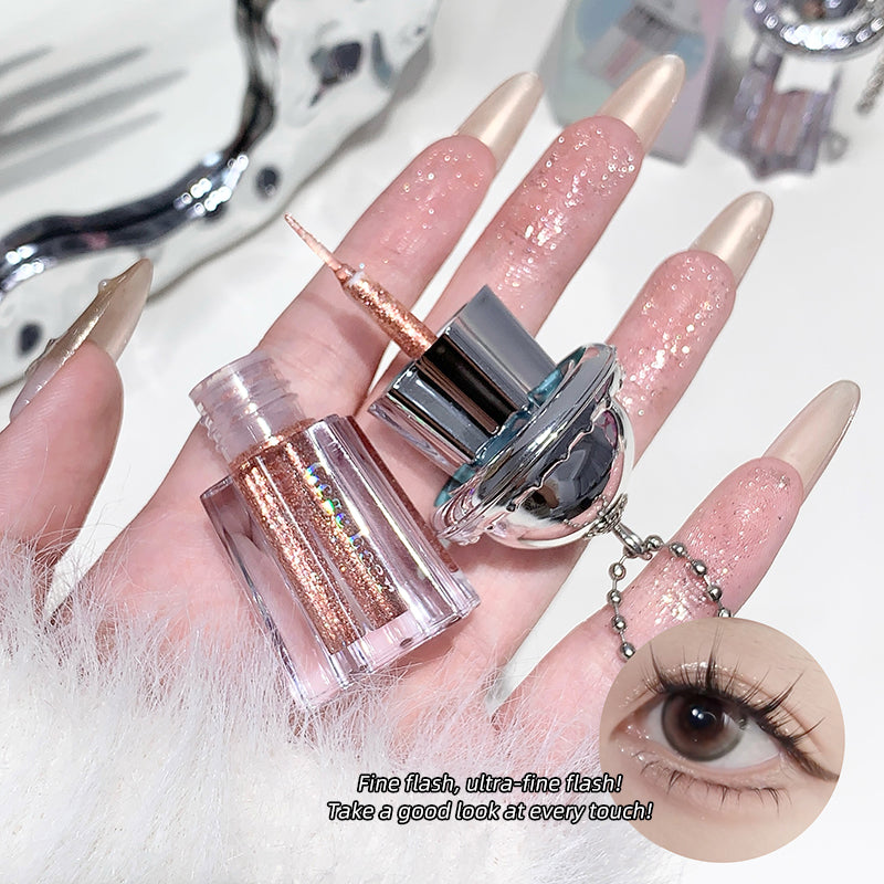 Nail art tool with glittery pink and gold design on a hand, close-up view.