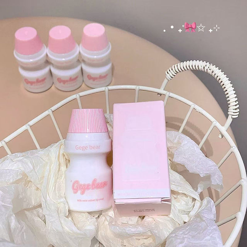 Pink and white cosmetic products including bottles and a box on a white wire basket.