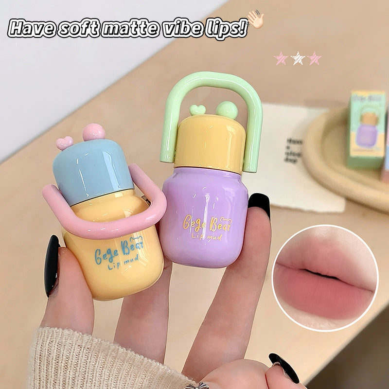 Two small bottles with colorful caps held by a hand, with a close-up of lips wearing the product.