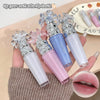 Set of lip glosses with decorative caps held by a hand, close-up of lips shown.