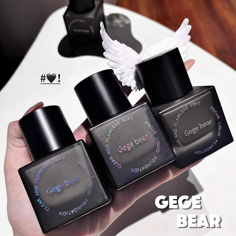 Four black Gege Bear perfume bottles held in a hand with a blurred background.
