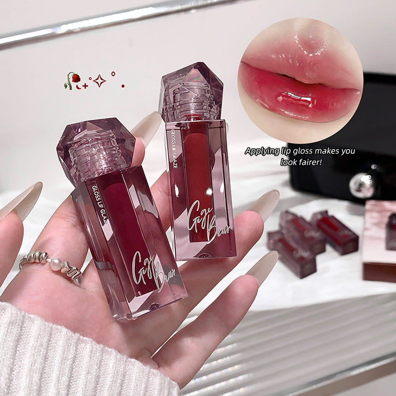 Two lip glosses held in a hand with a close-up of lips wearing the gloss and text 'Applying lip gloss makes you look fairer!'.