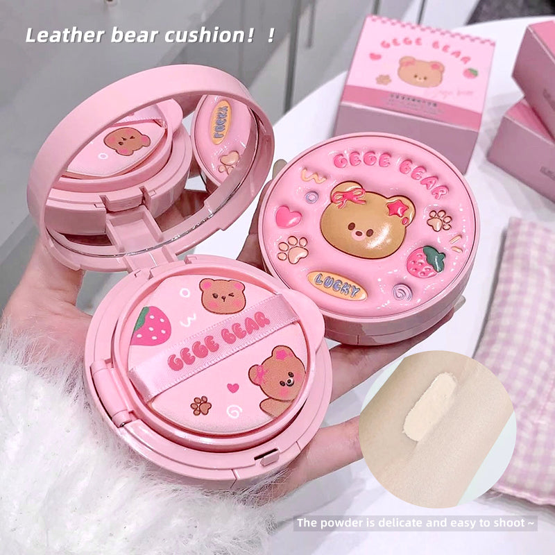 Pink bear cushion with open case on a white surface