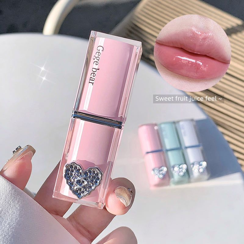 Pink lipstick with heart detail held by a hand, close-up of lips wearing the lipstick, and nail polish swatch.