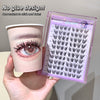 Eyelash extension tray with a cup featuring an eye illustration, held by a hand.