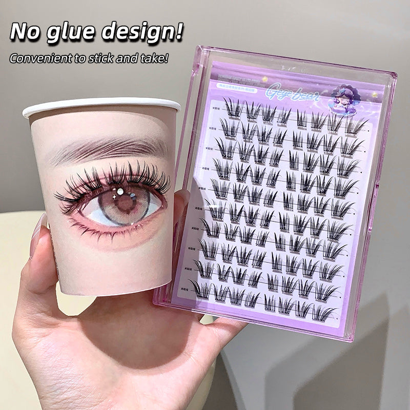 Eyelash extension tray with a cup featuring an eye illustration, held by a hand.