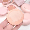 Compact powder in a pink case held by a hand with more cases in the background.
