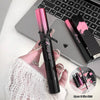 Hand holding a black and pink cosmetic product with a laptop in the background