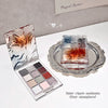Makeup palette with water ripple design and a clear glass container on a white surface.