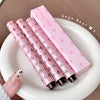 Set of pink lip glosses with decorative patterns on a white plate, branded 'Gege Bear'.