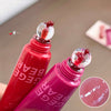 Two red lip gloss bottles with a close-up of the product on a neutral background